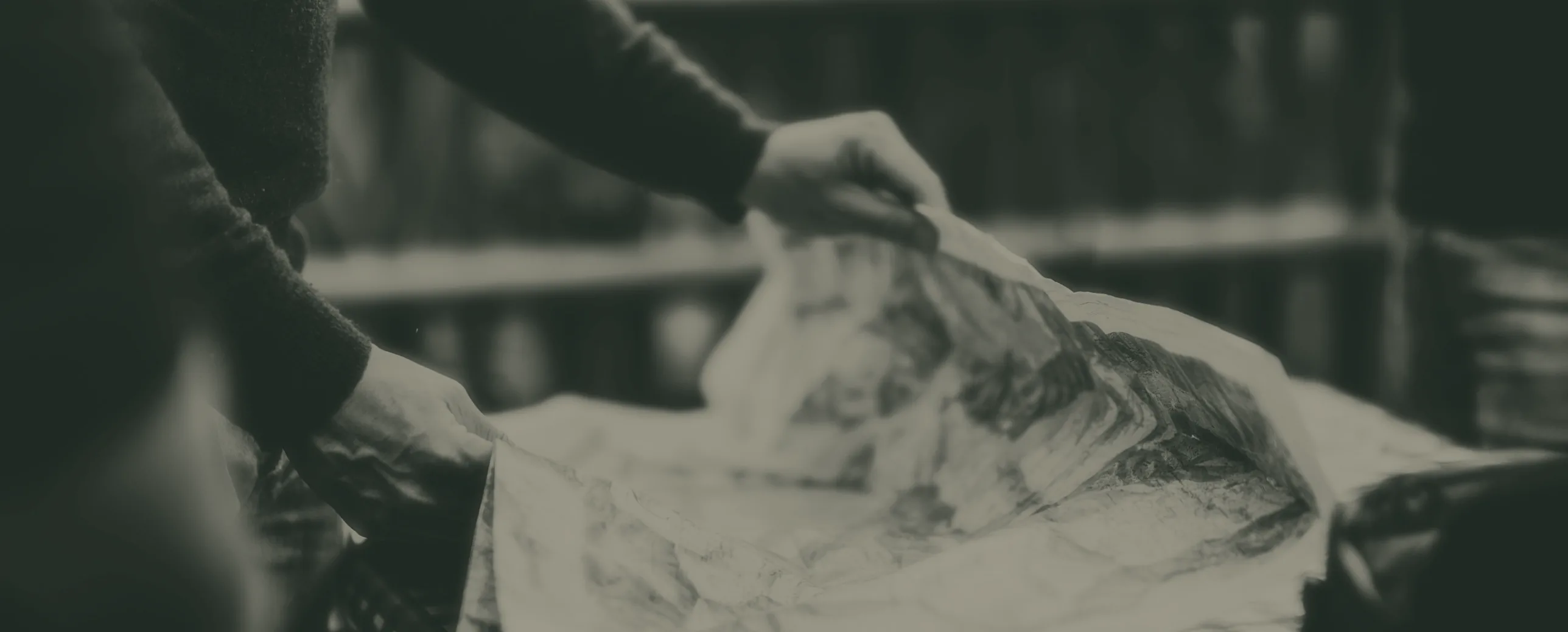 Hands opening a map on a table